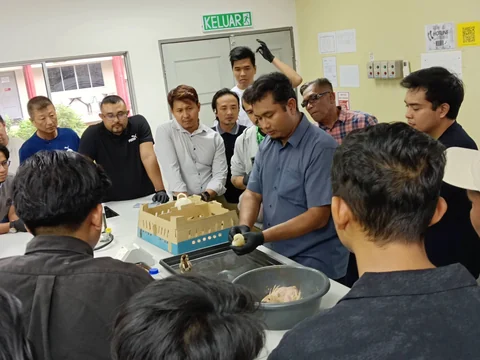 Pengajar menunjukkan teknik pengendalian anak unggas kepada peserta.