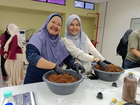 Dua peserta menyediakan media tanaman di makmal.